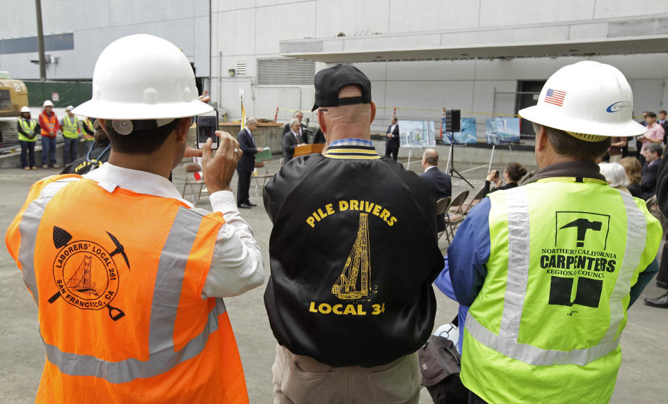 Union construction workers look on as San Francisco Mayor Ed Lee speaks during a groundbreaking ceremony for a new traffic control tower at San Francisco International Airport Monday, July 9, 2012 in San Francisco. The airport is getting a new control tower with a unique design that resembles a torch, not the traditional lollipop shape of other towers. The FAA expects to start using the 221-foot tall facility in 2015. (AP Photo/Eric Risberg)