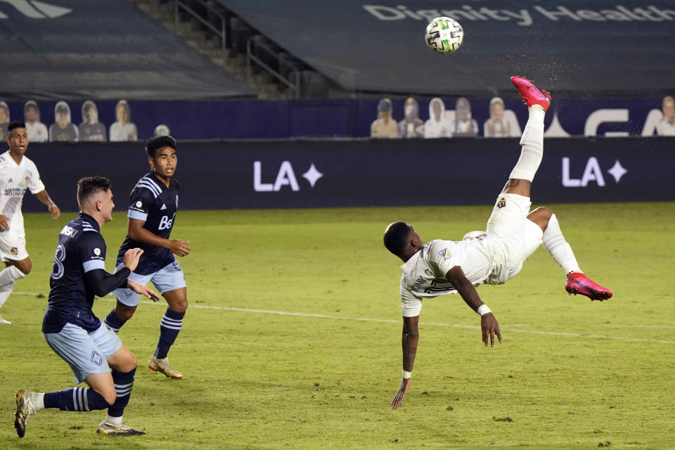 Los Angeles Galaxy's Yony Gonzalez, right, takes a shot on goal with a scissor kick during the first half of an MLS soccer match against the Vancouver Whitecaps, Sunday, Oct. 18, 2020, in Carson, Calif. (AP Photo/Marcio Jose Sanchez)