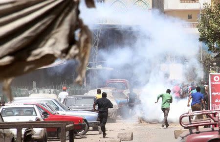 Protesters, supporters of the Muslim Brotherhood, run from tear gas thrown by police, during a protest in the Matariya area in Cairo, August 14, 2014. REUTERS/Al Youm Al Saabi Newspaper