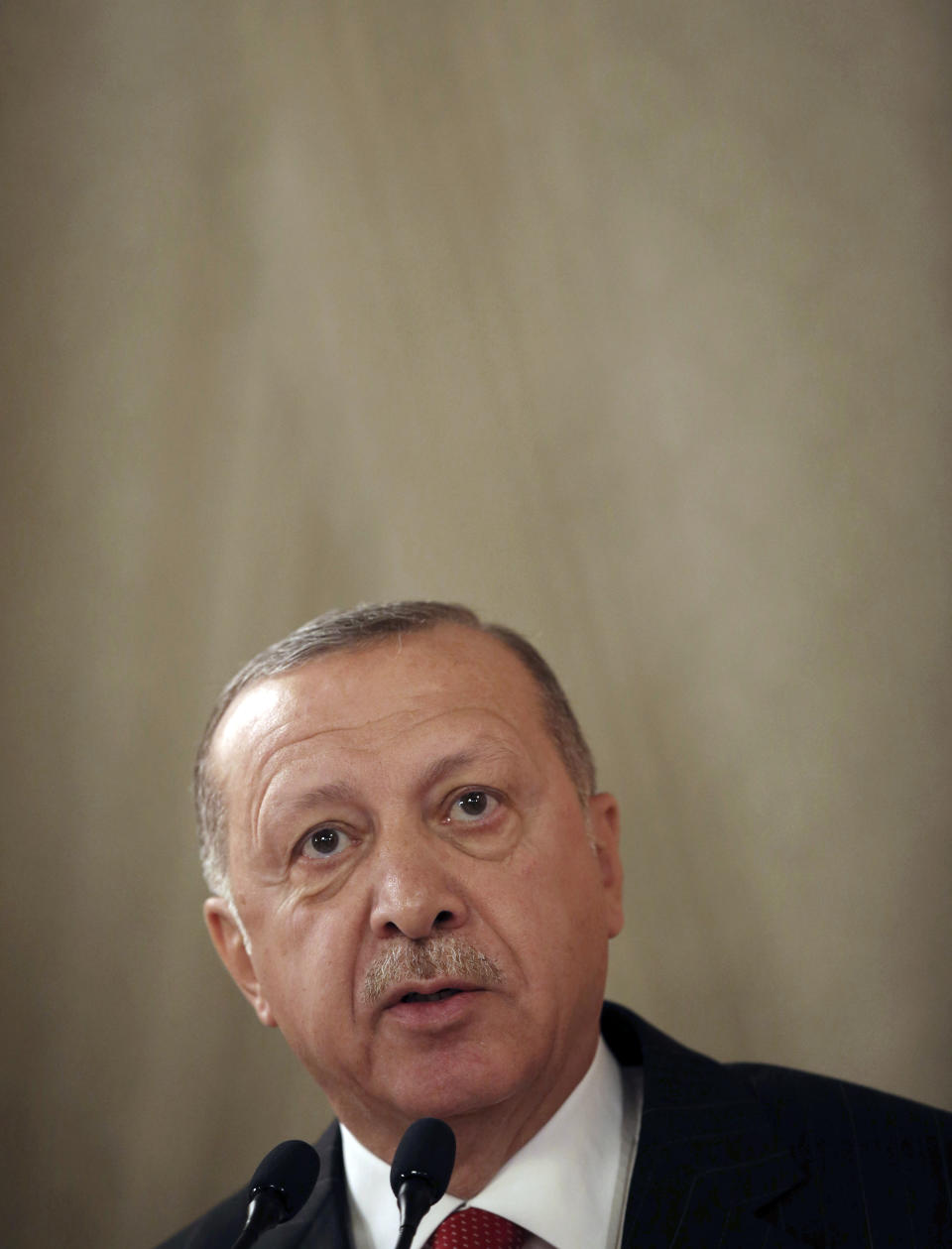 Turkey's President Recep Tayyip Erdogan addresses a conference of parliament speakers in Istanbul, Friday, Oct. 11, 2019. Erdogan says his county "will not take a step back" from its offensive against Syrian Kurdish militants it sees as a national security threat, defying serious warnings from the United States and other Western nations. (Presidential Press Service via AP, Pool)