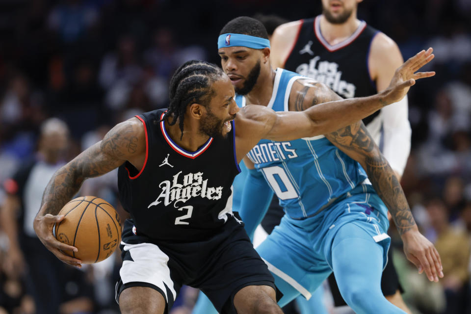 Los Angeles Clippers forward Kawhi Leonard (2) protects the ball from Charlotte Hornets forward Miles Bridges (0) during the second half of an NBA basketball game in Charlotte, N.C., Sunday, March 31, 2024. (AP Photo/Nell Redmond)