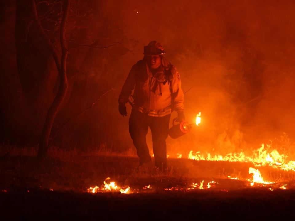 A Cal Fire firefighter lights a backfire while battling the Oak Fire on July 23, 2022 near Mariposa, California.