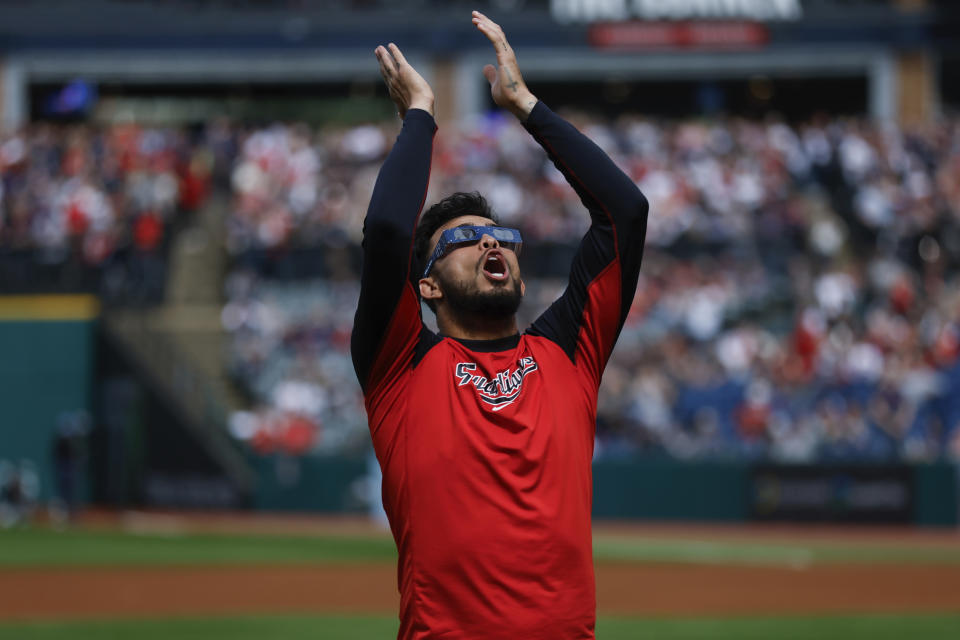 Cleveland Guardians third baseman Gabriel Arias uses special glasses to watch the total solar eclipse, Monday, April 8, 2024, in Cleveland. (AP Photo/Ron Schwane)