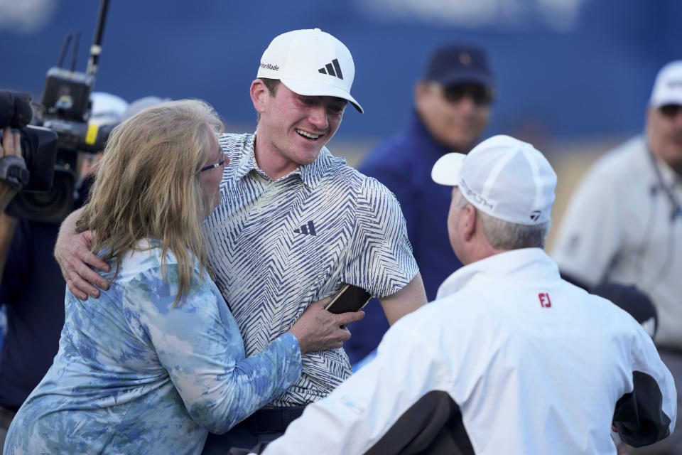 Nick Dunlap embraces his mother, Charlene Dunlap, left, and father Jim Dunlap, after winning the American Express golf tournament, Sunday, Jan. 21, 2024, in La Quinta, Calif. (AP Photo/Ryan Sun)