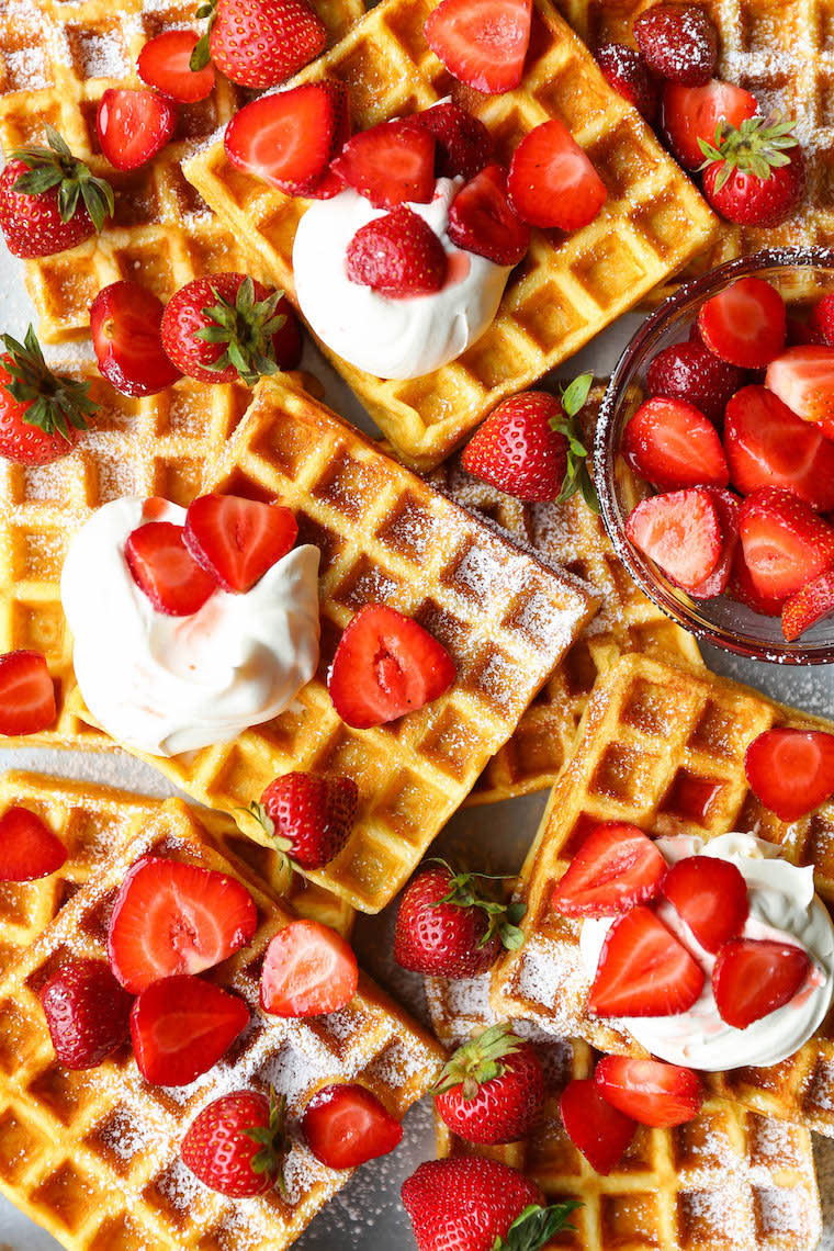 Waffles with powdered sugar and strawberries.