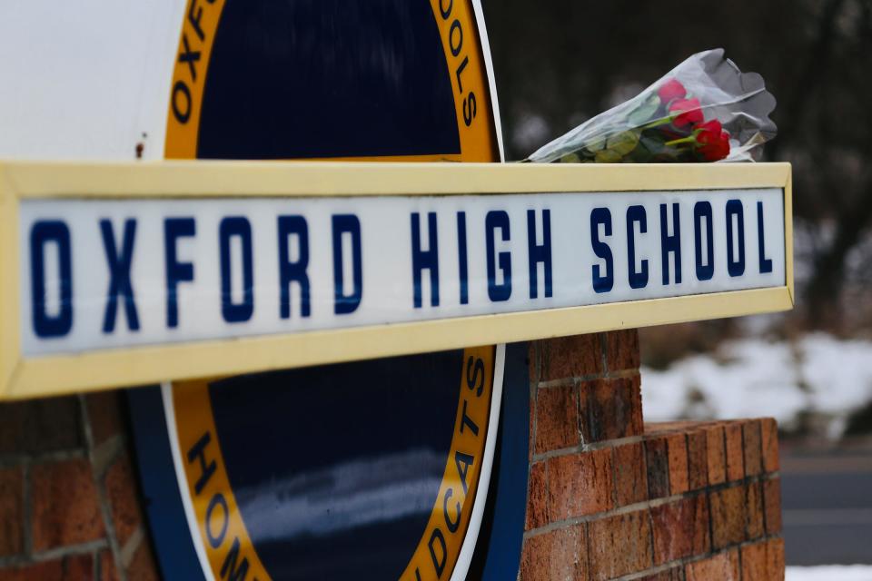 A bouquet of roses sits on the sign on Dec. 1, 2021, outside of Oxford High School in Oxford, Mich., to show his support for the community after the school shooting at the school.