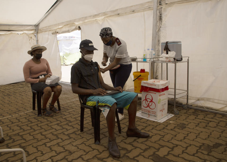 A man receives a dose of a COVID-19 vaccine at a vaccine centre, in Soweto, Monday, Nov. 29, 2021. The World Health Organization has urged countries not to impose flight bans on southern African nations due to concerns over the new omicron variant. (AP Photo/Denis Farrell)