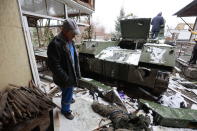 EDS NOTE: GRAPHIC CONTENT - A man looks at a Russian soldier's body lying next to a military vehicle on a road in the town of Bucha close to Kyiv, Ukraine, Tuesday, 2022. Russia on Tuesday stepped up shelling of Kharkiv, Ukraine's second-largest city, pounding civilian targets there. Casualties mounted and reports emerged that more than 70 Ukrainian soldiers were killed after Russian artillery recently hit a military base in Okhtyrka, a city between Kharkiv and Kyiv, the capital. (AP Photo/Serhii Nuzhnenko)