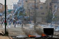 <p>Palestinians throw stones towards Israeli security forces during clashes after a protest marking the 70th anniversary of Nakba — also known as Day of the Catastrophe in 1948 — and against the US’ relocation of its embassy from Tel Aviv to Jerusalem, at the main entrance of the occupied West Bank city of Bethlehem on May 15, 2018. (Photo: Musa Al Shaer/AFP/Getty Images) </p>