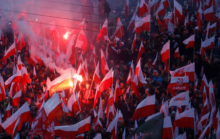 People carry Polish flags and flares during a march marking the 100th anniversary of Polish independence in Warsaw, Poland November 11, 2018. REUTERS/Kacper Pempel