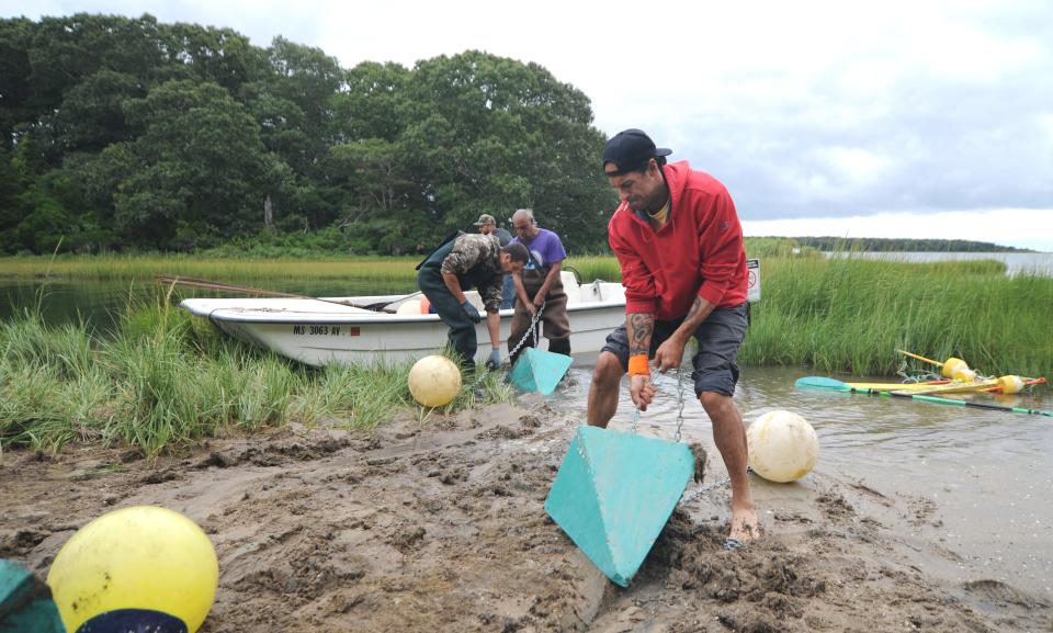 Assistant farm manager David Pocknett Jr. helps to unload buoys off a truck and onto a boat Wednesday. The First Light Shellfish Farm crew was out Wednesday setting buoys to mark the coordinates of the Mashpee Wampanoag Tribe's farm in Popponesset Bay in Mashpee. To see more photos, go to www.capecodtimes.com/news/photo-galleries.