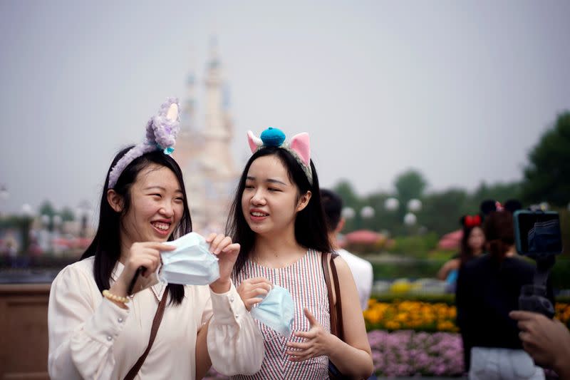 FILE PHOTO: Visitors hold face masks at the Shanghai Disneyland