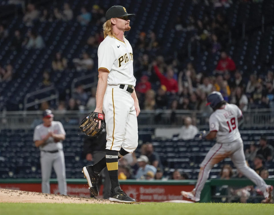 Pittsburgh Pirates relief pitcher Sam Howard, center, awaits a new ball as Washington Nationals' Josh Bell (19) runs the bases after hitting a solo home run during the sixth inning of a baseball game Friday, Sept. 10, 2021, in Pittsburgh. Nationals first base coach Randy Knorr is at left. (AP Photo/Keith Srakocic)