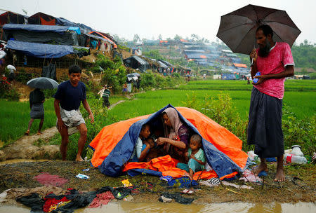 Rohingya refugees sit on the roadside as they take shelter during rain in Cox's Bazar, Bangladesh, September 17, 2017. REUTERS/Mohammad Ponir Hossain