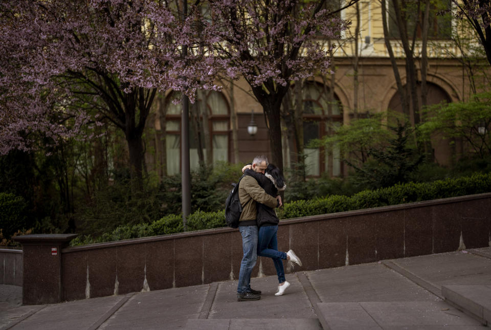 A couple embrace in central Kyiv, on Saturday, April 30, 2022. (AP Photo/Emilio Morenatti)