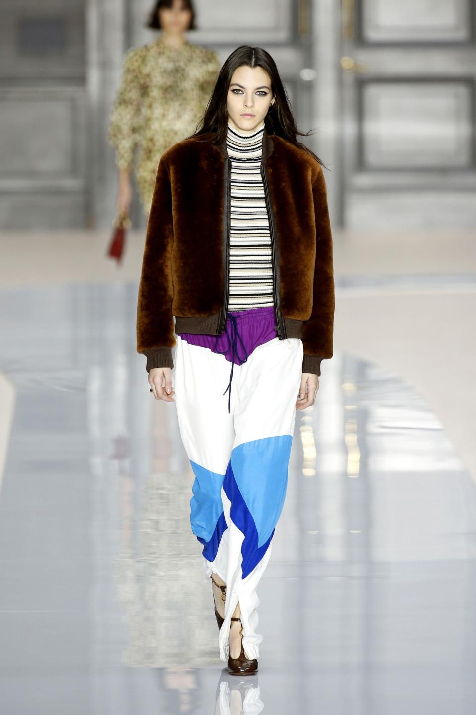 Model wears a color-block track pant with brown velvet bomber jacket at the Chloé Fall/Winter 2017 show