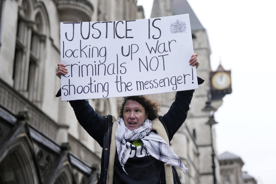 A protester holds a poster at the Royal Courts of Justice in London, Wednesday, Feb. 21, 2024. Julian Assange's lawyers are on their final U.K. legal challenge to stop the WikiLeaks founder from being sent to the United States to face spying charges. The 52-year-old has been fighting extradition for more than a decade, including seven years in self-exile in the Ecuadorian Embassy in London and the last five years in a high-security prison. (AP Photo/Alastair Grant)