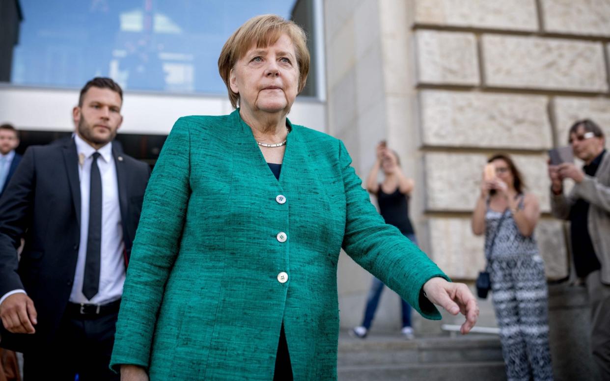 Mrs Merkel is locked in an escalating row with her interior minister - DPA
