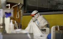 A healthcare worker talks to a COVID-19 patient in an intensive care unit (ICU) at Na Bulovce hospital in Prague, Czech Republic, Thursday, Oct. 1, 2020. A record surge of new coronavirus infections in the Czech Republic in September has been followed by a record surge of those hospitalized with COVID-19. The development has started to put the health system in the country under serious pressure for the first time since the pandemic hit Europe. (AP Photo/Petr David Josek)