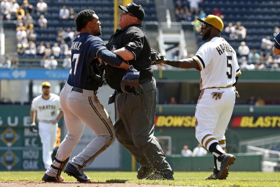 Milwaukee Brewers' Carlos Gomez, left, tries to get past umpire Fieldin Culbreth, center, as Pittsburgh Pirates third baseman Josh Harrison (5) tries to get to Pirates starting pitcher Gerrit Cole during the third inning of a baseball game in Pittsburgh, Sunday, April 20, 2014. A dugouts clearing brawl ensued. (AP Photo/Gene J. Puskar)