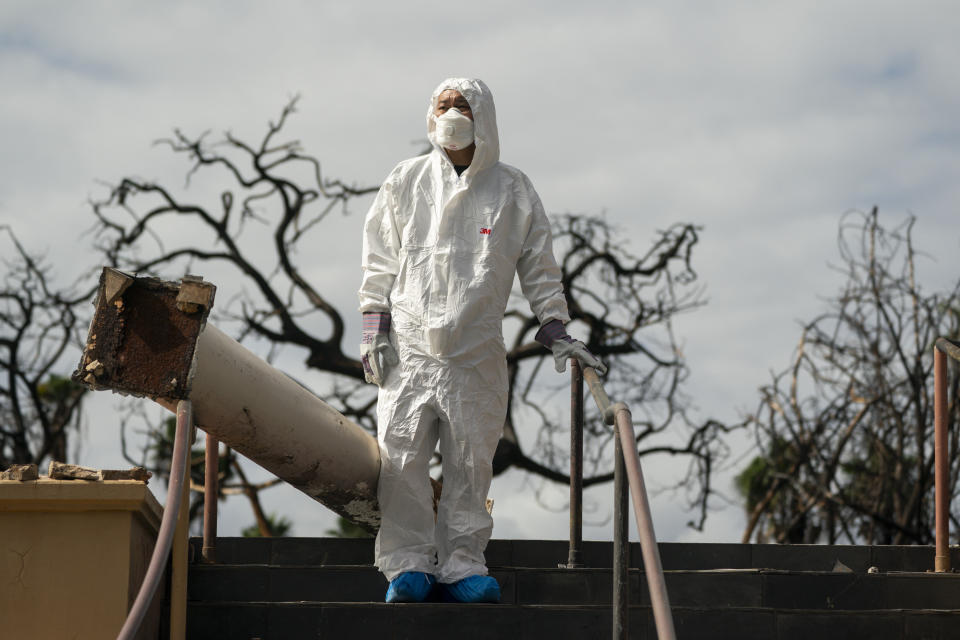 Rev. Ai Hironaka, resident minister of the Lahaina Hongwanji Mission, stands for a portrait at the stairs of his temple destroyed by wildfire, Thursday, Dec. 7, 2023, in Lahaina, Hawaii. Recovery efforts continue after the August wildfire that swept through the Lahaina community on Hawaiian island of Maui, the deadliest U.S. wildfire in more than a century. (AP Photo/Lindsey Wasson)