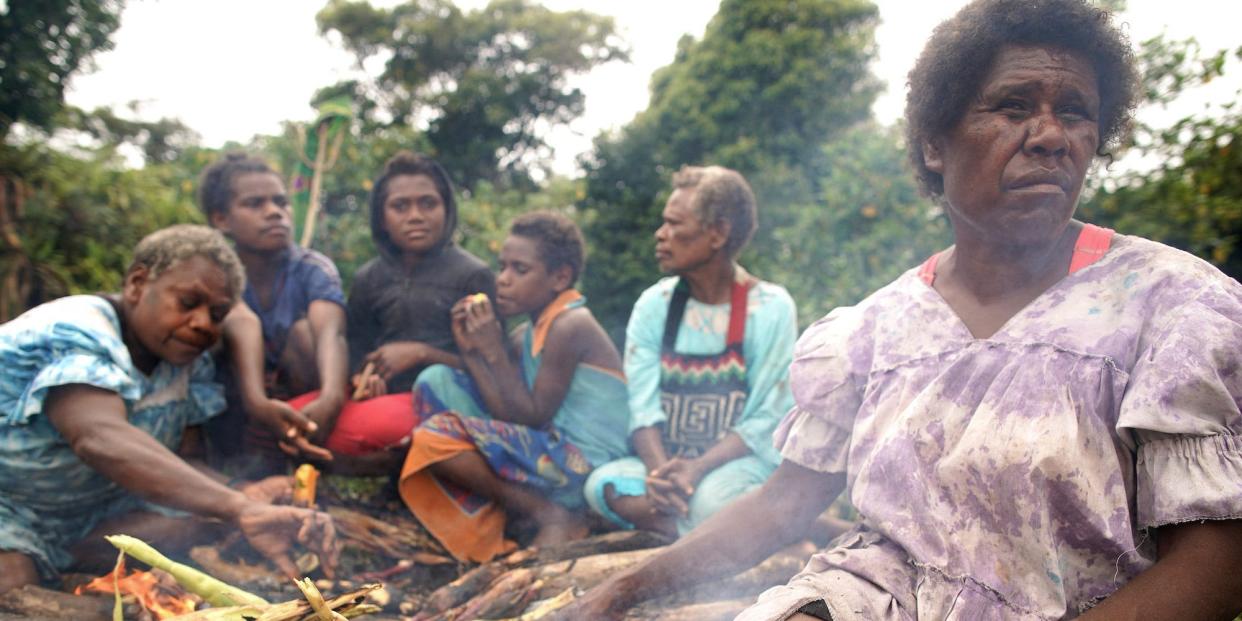 Ruth Nafow (R) cooks corn to sell at a local farmer's market on December 06, 2019 in Tanna, Vanuatu. Asked about climate change, she said, 'It's a really big concern. This will affect our crops in one way or another.'