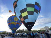 Hot air balloons prepare to lift off as part of a re-enactment of the first Albuquerque International Balloon Fiesta in 1972 during a special event at Coronado Center in Albuquerque, New Mexico, on Friday, Sept. 30, 2022. Hundreds of balloons will ascend during the nine-day annual fiesta that has drawn pilots and spectators from across the globe for 50 years. (AP Photo/Susan Montoya Bryan)