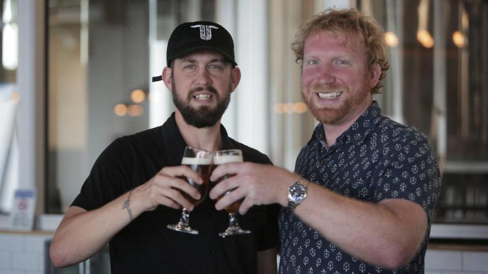 Lance Aschliman y Zachary Swanson, copropietarios de Unbranded Brewing Company, brindan por la apertura de la cervecería en 2020.