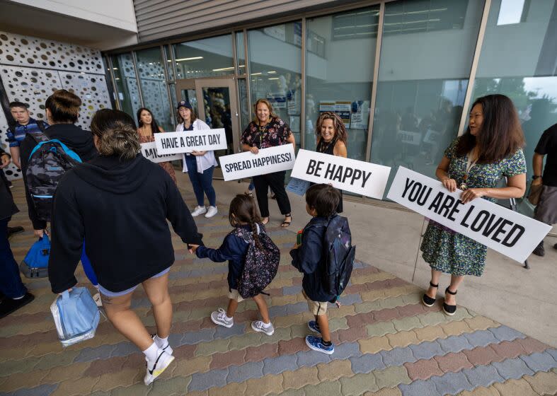 Anaheim, CA - August 10: Teachers hold signs of encouragement as kids and their parents arrive for the first day of school for the Anaheim Elementary School District at Roosevelt Elementary in Anaheim Thursday, Aug. 10, 2023. (Allen J. Schaben / Los Angeles Times)