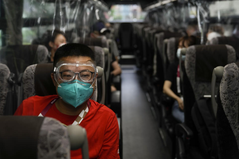 Hua Zhang, of the China Media Group, wears protective goggles while riding a media bus ahead the 2020 Summer Olympics, Wednesday, July 14, 2021, in Tokyo. (AP Photo/Jae C. Hong)