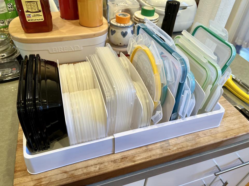 a lid organizer with lots of lids and containers