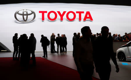 FILE PHOTO - Visitors look at car models on the Toyota stand during the 88th Geneva International Motor Show in Geneva, Switzerland, March 7, 2018. REUTERS/Denis Balibouse