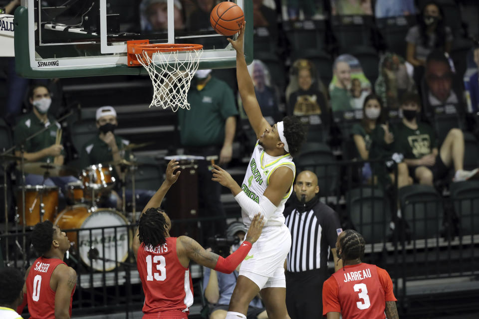 South Florida's Michael Durr shoots past Houston defenders Marcus Sasser (0), J'Wan Roberts (13) and DeJon Jarreau (3) during the first half of an NCAA college basketball game Wednesday, Feb. 10, 2021, in Tampa, Fla. (AP Photo/Mike Carlson)