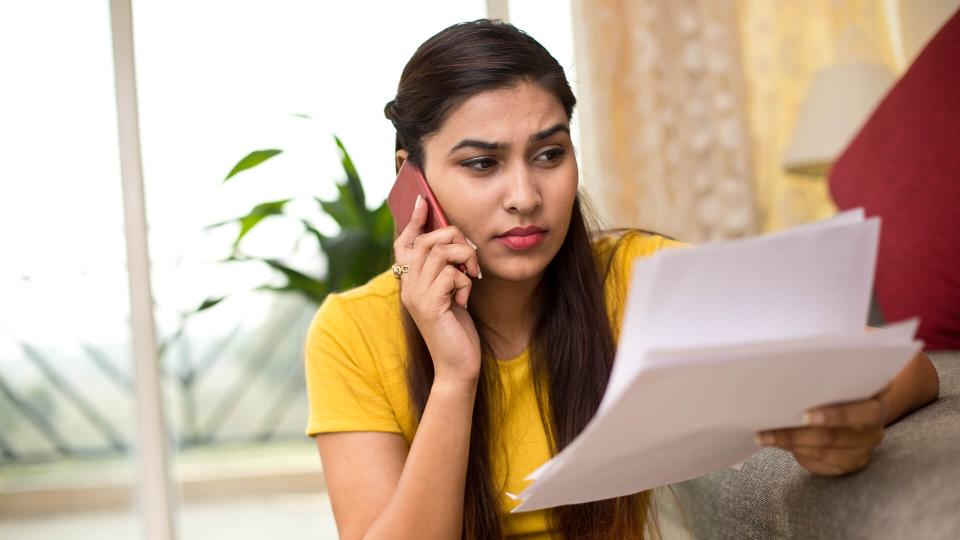 Woman checking her financial bills by calling at home.