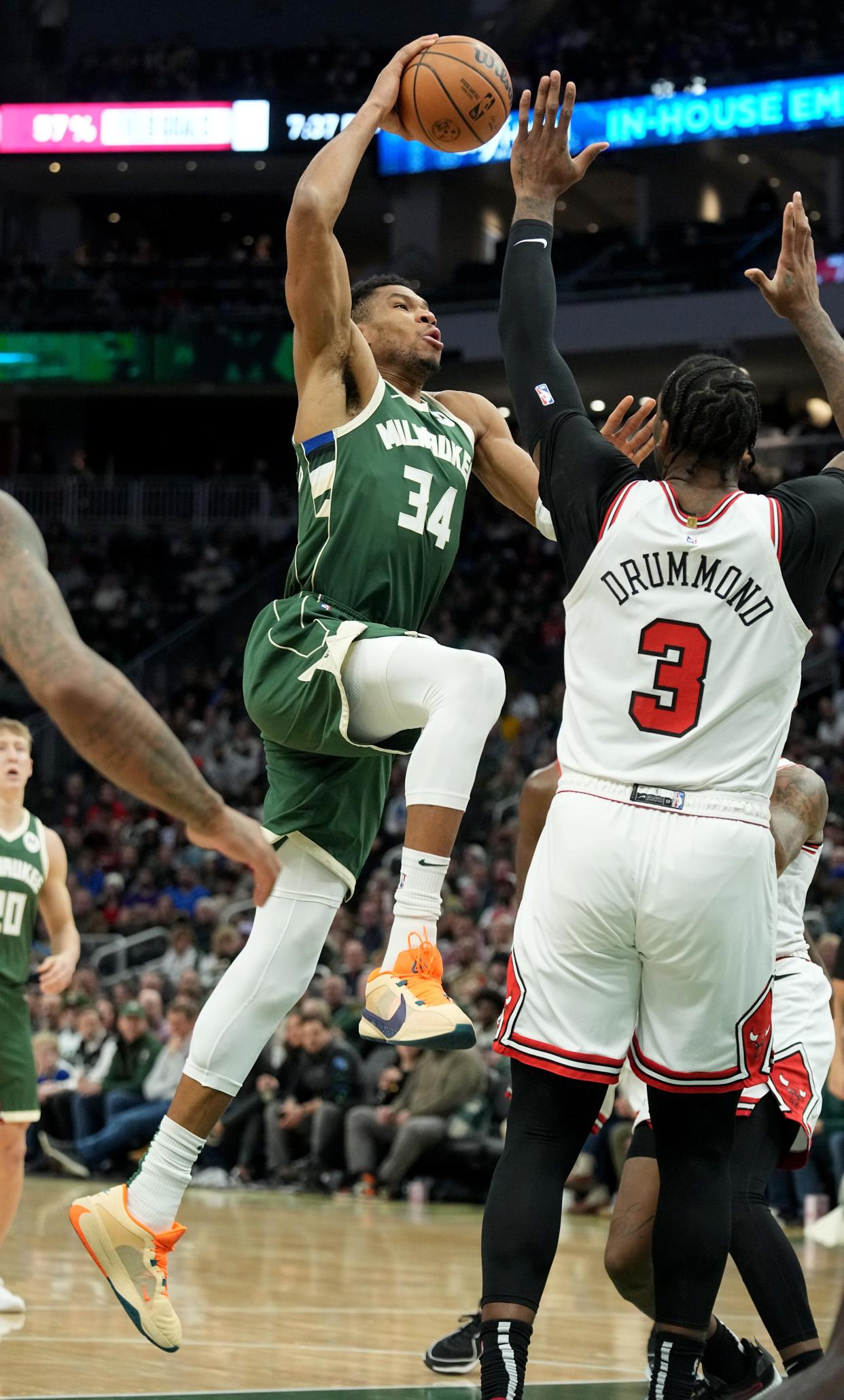 Milwaukee Bucks forward Giannis Antetokounmpo draws a foul from Chicago Bulls center Andre Drummond during the first half Monday at Fiserv Forum.