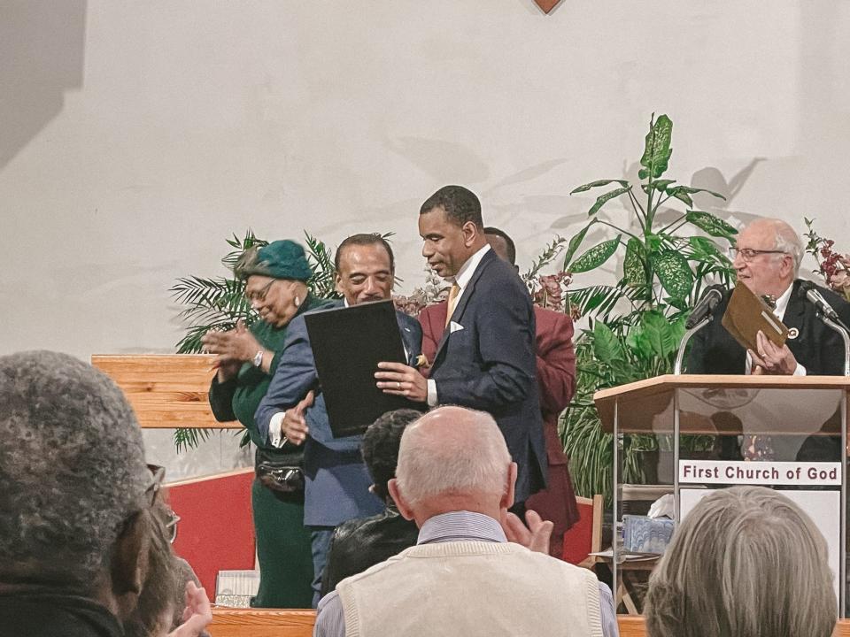 Rev. Lewis Stewart accepting an award from Mayor Malik Evans.