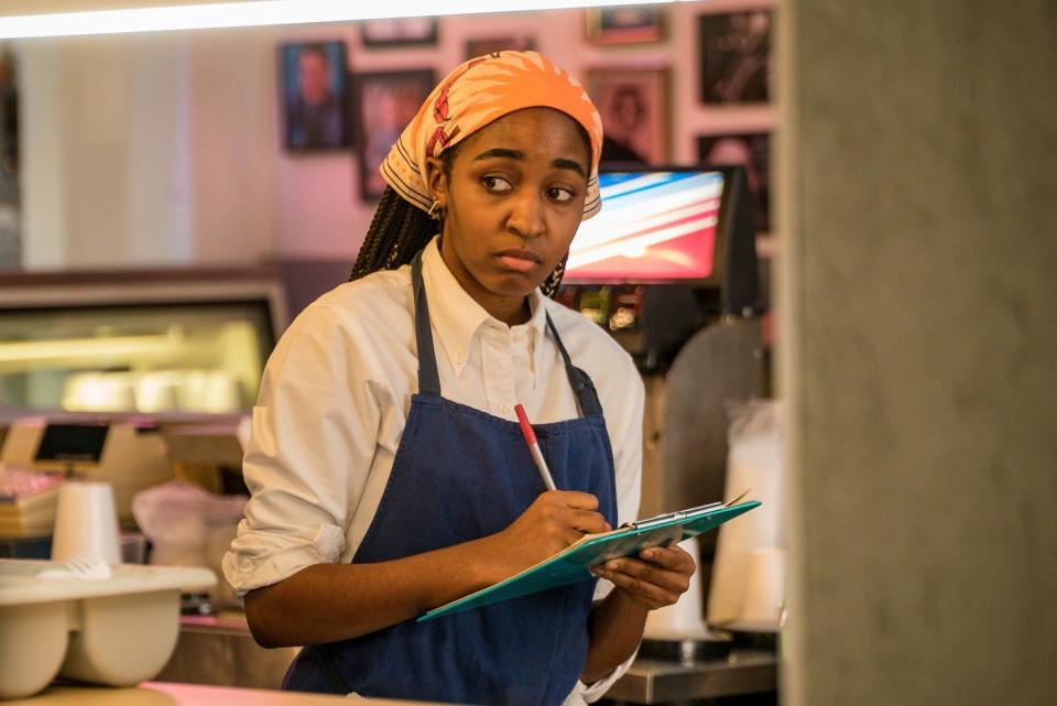 her character in the kitchen with a clip board