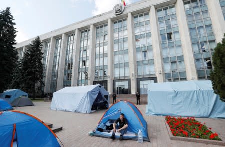 Supporter of the Democratic Party of Moldova sits in a tent during a rally in front of the government building in Chisinau