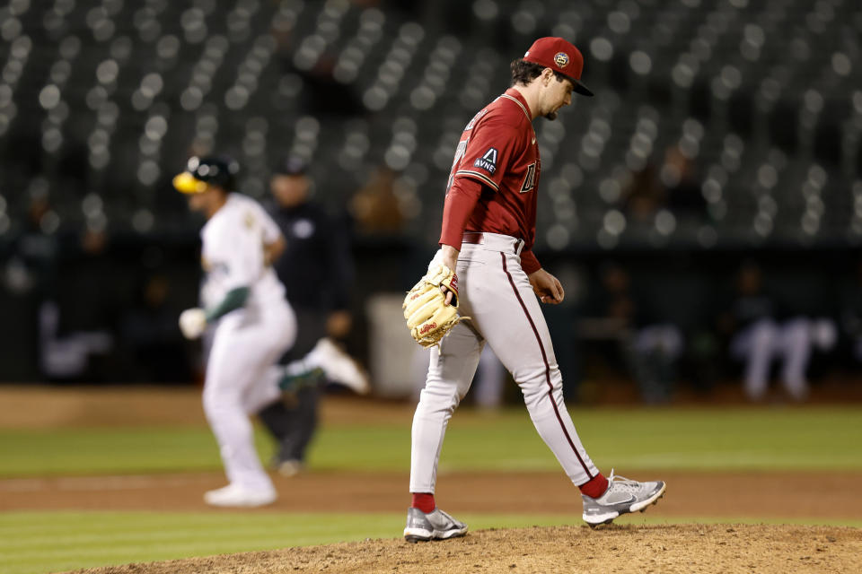 Arizona Diamondbacks relief pitcher Kyle Nelson, right, walks on the mound as Oakland Athletics' Ryan Noda, left, runs the bases after hitting a grand slam during the seventh inning of a baseball game in Oakland, Calif., Tuesday, May 16, 2023. (AP Photo/Jed Jacobsohn)
