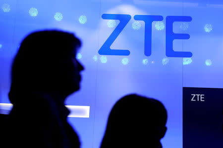 FILE PHOTO: People walk past a ZTE logo outside its booth at the Mobile World Congress in Barcelona, Spain, Feb. 25, 2019. REUTERS/Sergio Perez/File Photo