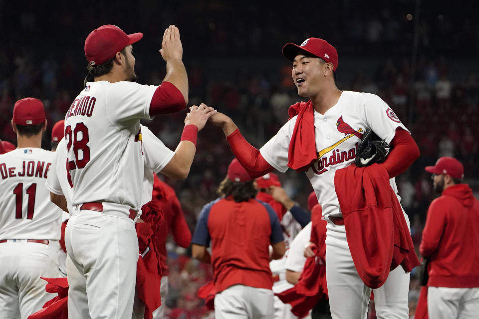 St. Louis Cardinals' Kwang Hyun Kim, right, celebrates with teammate Nolan Arenado (28) after the Cardinals win over the Milwaukee Brewers in a baseball game to clinch a playoff spot Tuesday, Sept. 28, 2021, in St. Louis. (AP Photo/Jeff Roberson)