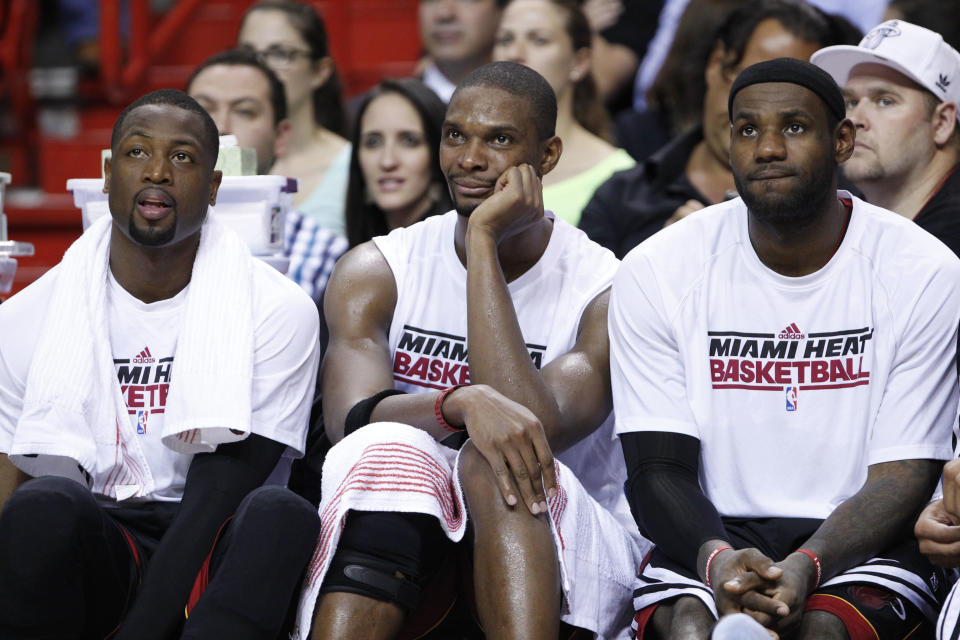 Miami Heat guard Dwyane Wade, left, forward Chris Bosh, and forward LeBron James, right, sit on the bench during the fourth quarter of a preseason NBA basketball game against the New Orleans Hornets, Friday, Oct. 26, 2012 in Miami. The Hornets defeated the Heat 96-89. (AP Photo/Wilfredo Lee)