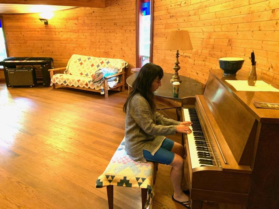 Alicia Araya, Azule's outgoing social media coordinator works on her piano chops in the artist residency's music room. The noprofit artist residency is located on 35 acres in the Trust community of Hot Springs.