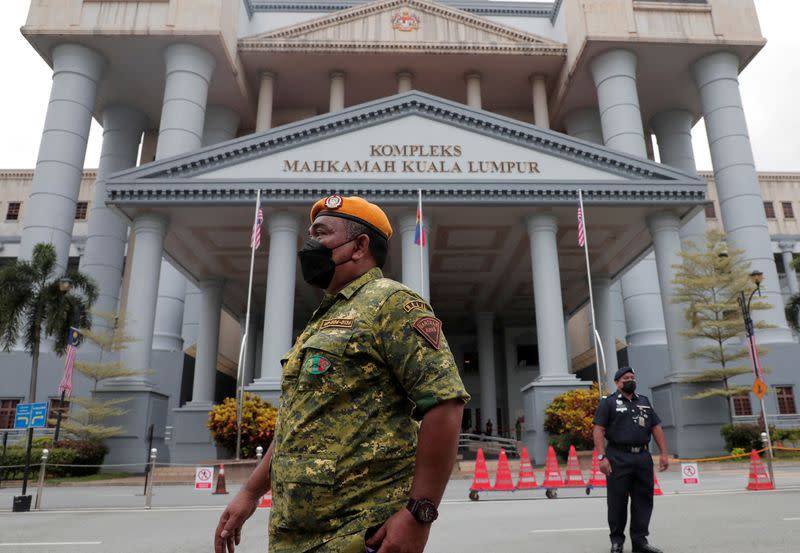 A Malaysia Volunteers Corps member and a police officer stand guard at Kuala Lumpur Court Complex in Kuala Lumpur