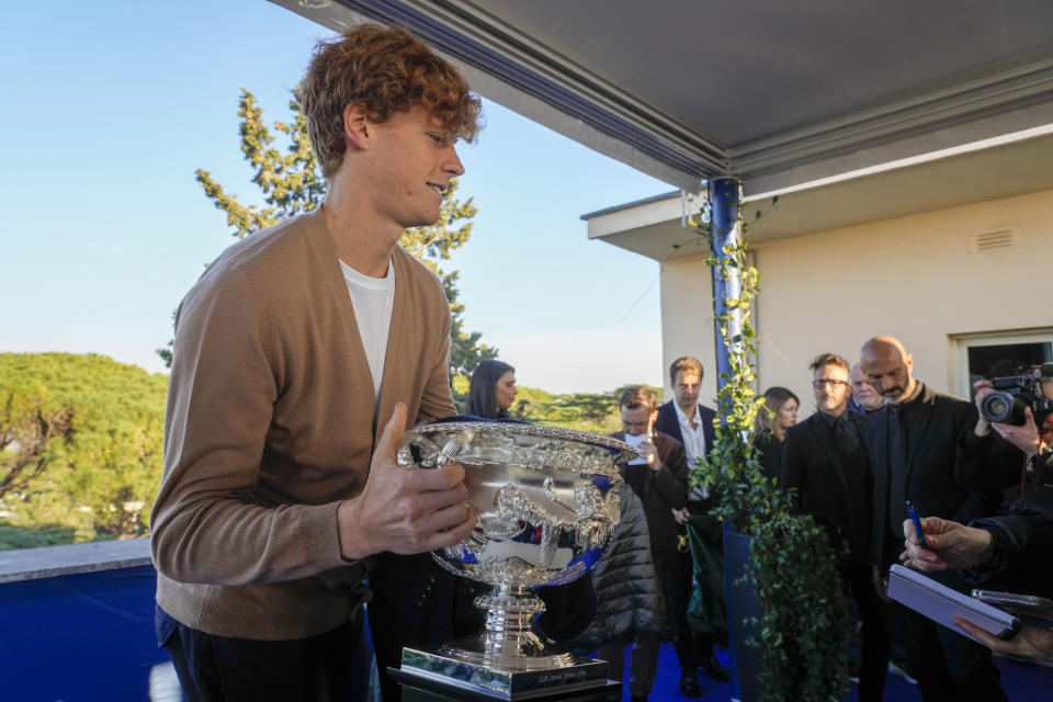 Italian tennis player Jannik Sinner carries the Australian Open trophy he won on Sunday at the end of a press conference in Rome, Wednesday, Jan. 31, 2024. Sinner, 22, was the the first Italian to win the Australian Open that is the first grand slam title of his career. (AP Photo/Gregorio Borgia)