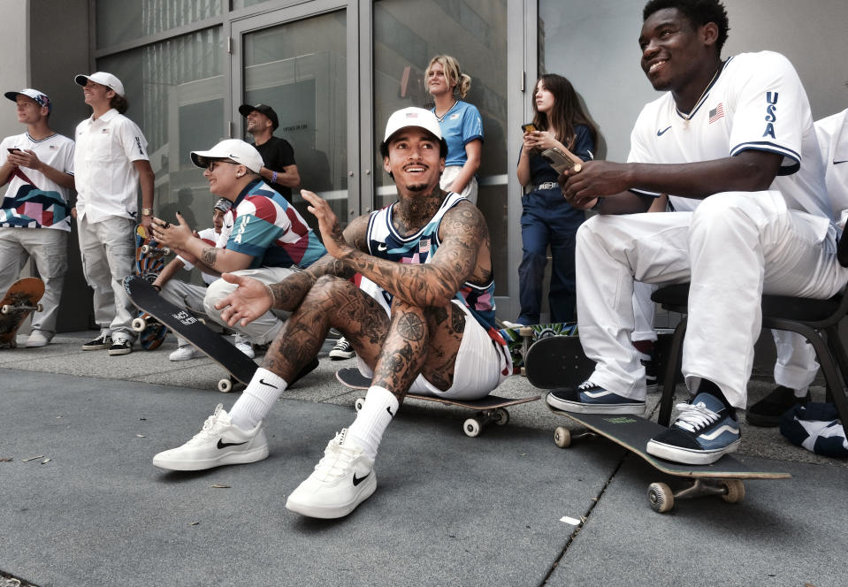 Nyjah Huston, center, laughs with teammate Zion Wright, right, before they are introduced with the rest of their team at a news conference in downtown Los Angeles on Monday, June 21, 2021. Huston and the rest of the first U.S. Olympic skateboarding team was introduced in Southern California on Monday where the sport was invented roughly 70 years ago. Skateboarding is an Olympic sport for the first time in Tokyo, and the Americans are expected to be a strong team. (AP Photo/Richard Vogel)