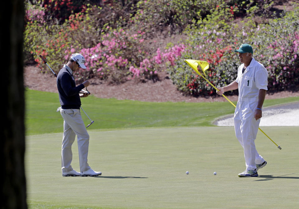 Adam Scott, of Australia, takes notes on the 13th green with caddie Steve Williams during a practice round for the Masters golf tournament Wednesday, April 9, 2014, in Augusta, Ga. (AP Photo/David J. Phillip)