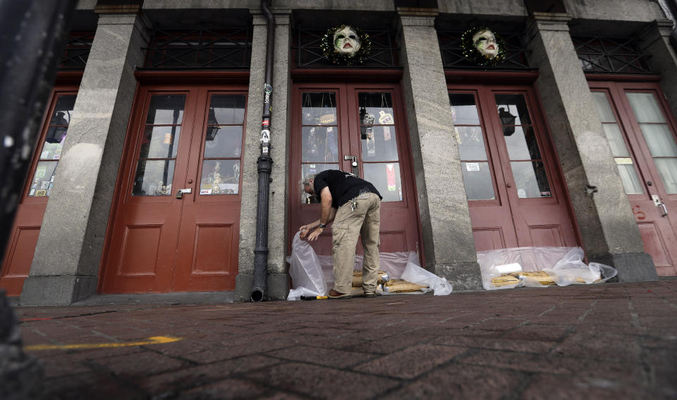 FILE - In this July 12, 2019, file photo Jake Summers puts concrete bags in front of a business in the French Quarter in New Orleans, ahead of Tropical Storm Barry. With earthquakes in California and Hurricane Barry striking states along the Gulf of Mexico and in the Midwest, small business owners should look at their insurance policies and determine how well covered they’d be in the event of a natural disaster. (AP Photo/David J. Phillip, File)