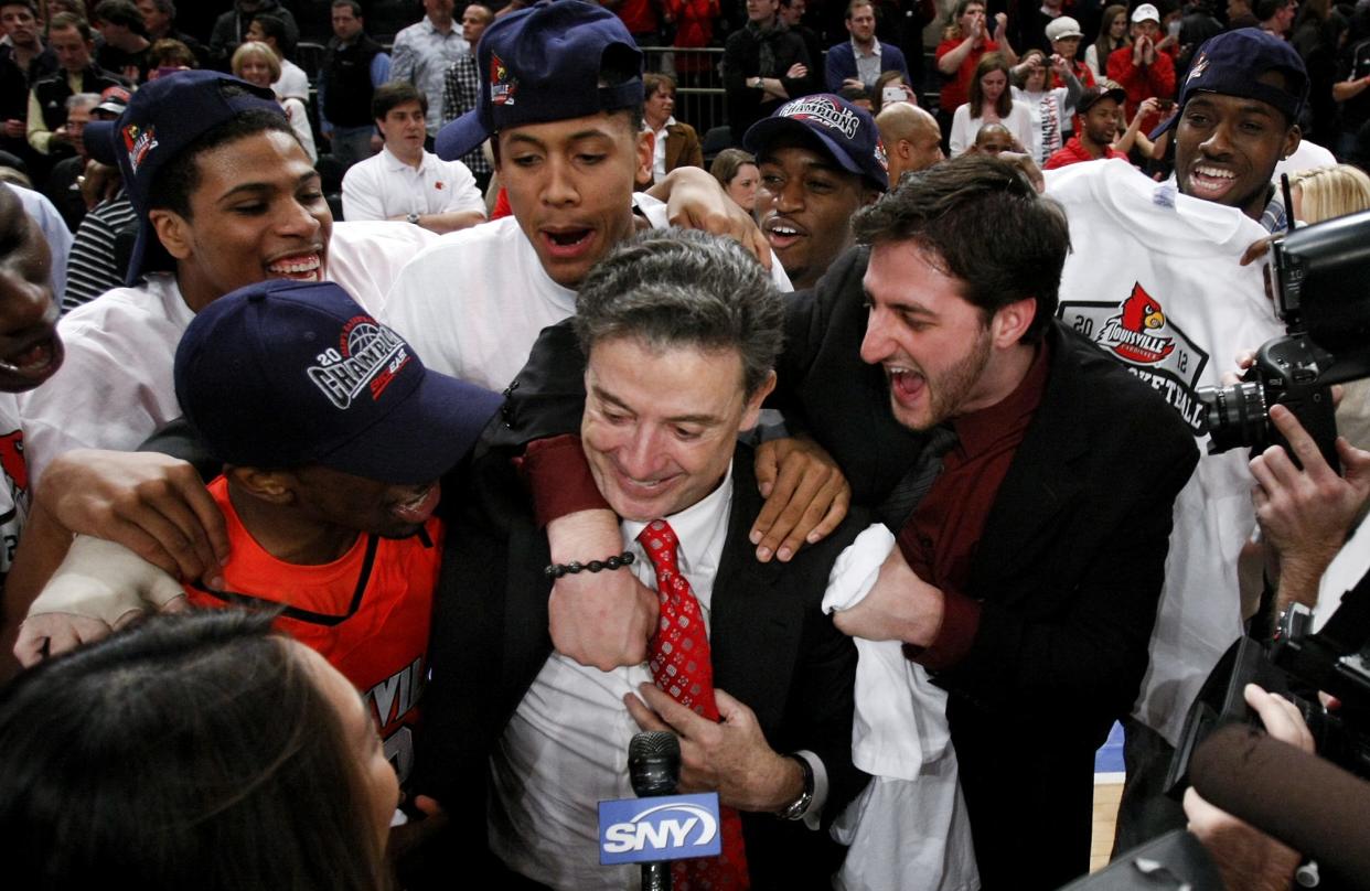 U of L coach Rick Pitino is embraced by players Russ Smith, left, and Mike Marra after they defeated Cincinnati to win the Big East championship at Madison Square Garden in March 2012.