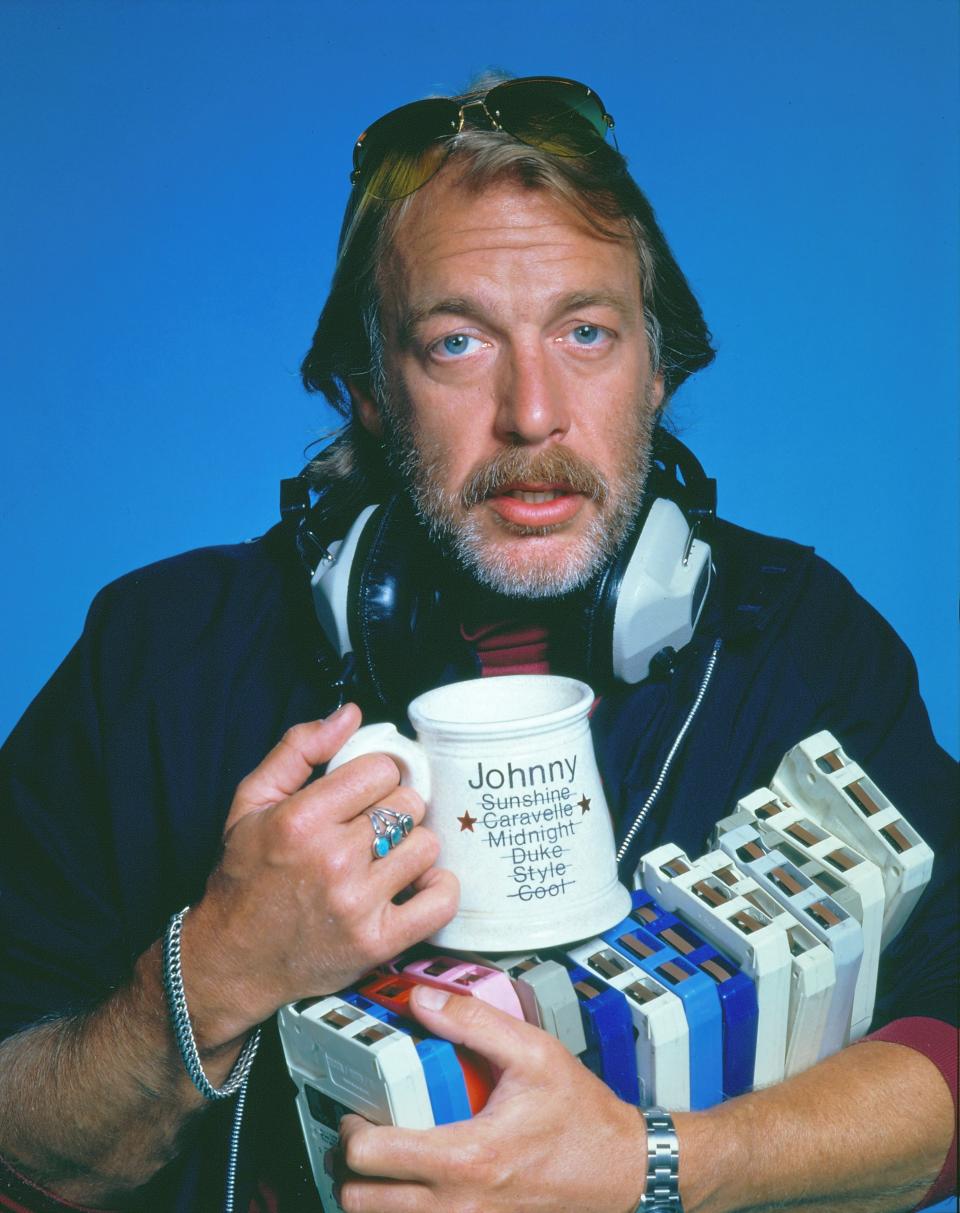 Howard Hesseman holding a mug and 8-track tapes